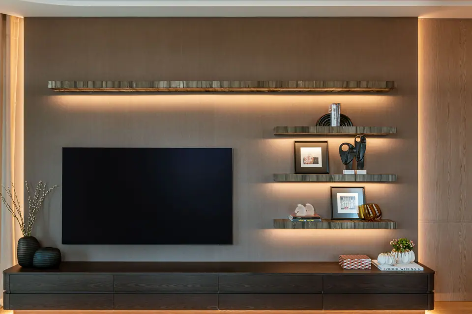 B.C.A. Kempinski Residences — Aydınlatmalı duvar raflı ve koyu konsollu TV duvarı