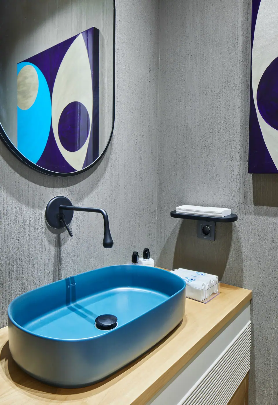 Ö.F. Mandarin Oriental Bodrum — Yuvarlak aynanın altında meşe tezgahta mavi çanak lavabo