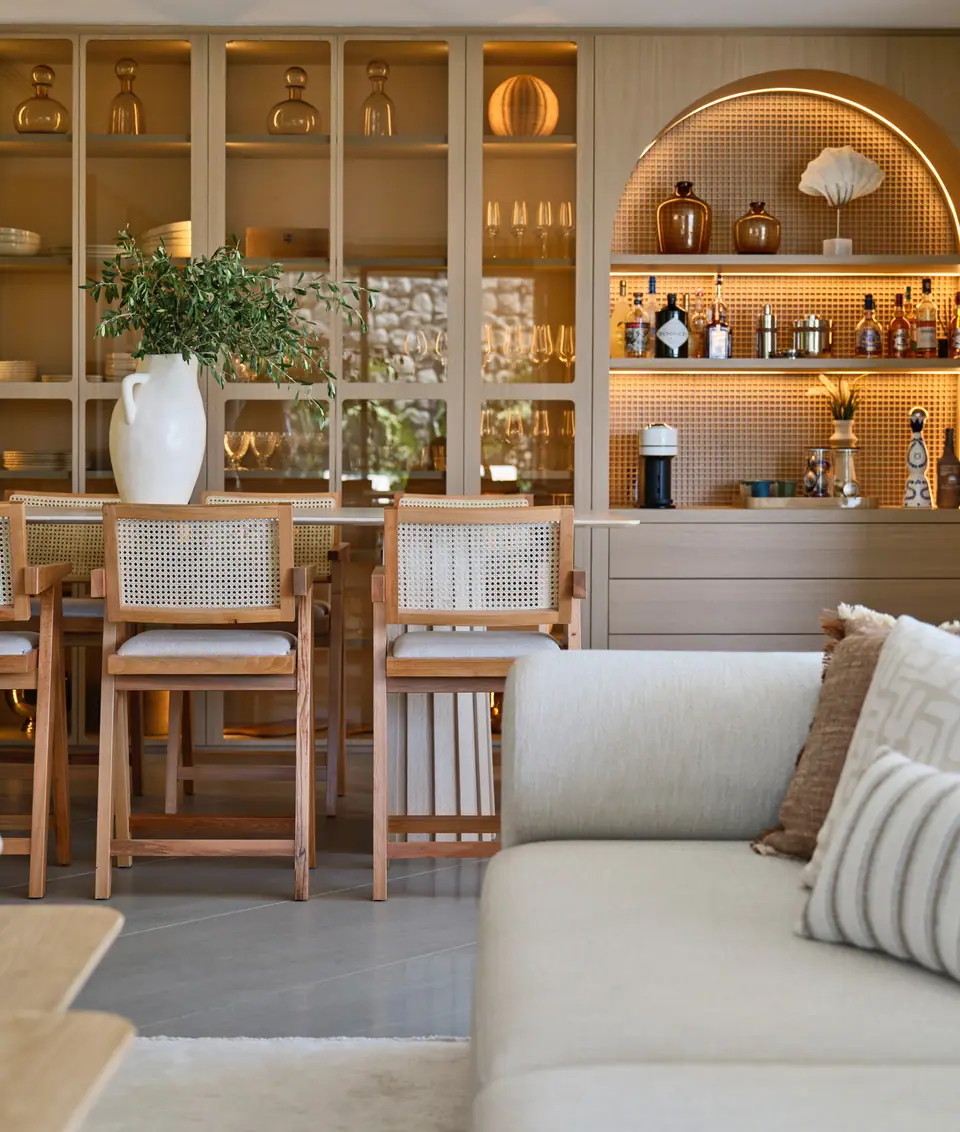 A.F. The One Bodrum — Yemek masasına ve aydınlatmalı bar raflarına bakan kanepe