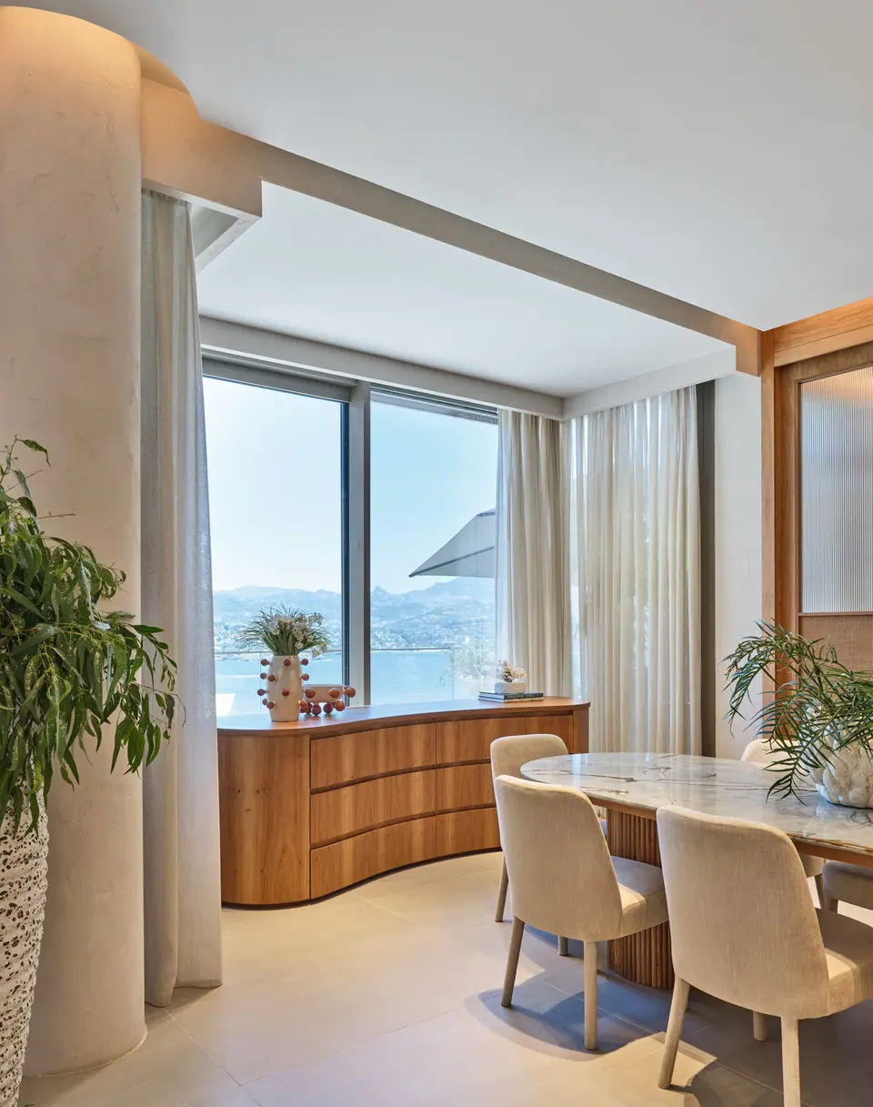 G.Ç. The One Bodrum — Kavisli meşe büfe, yemek masası ve deniz manzarası