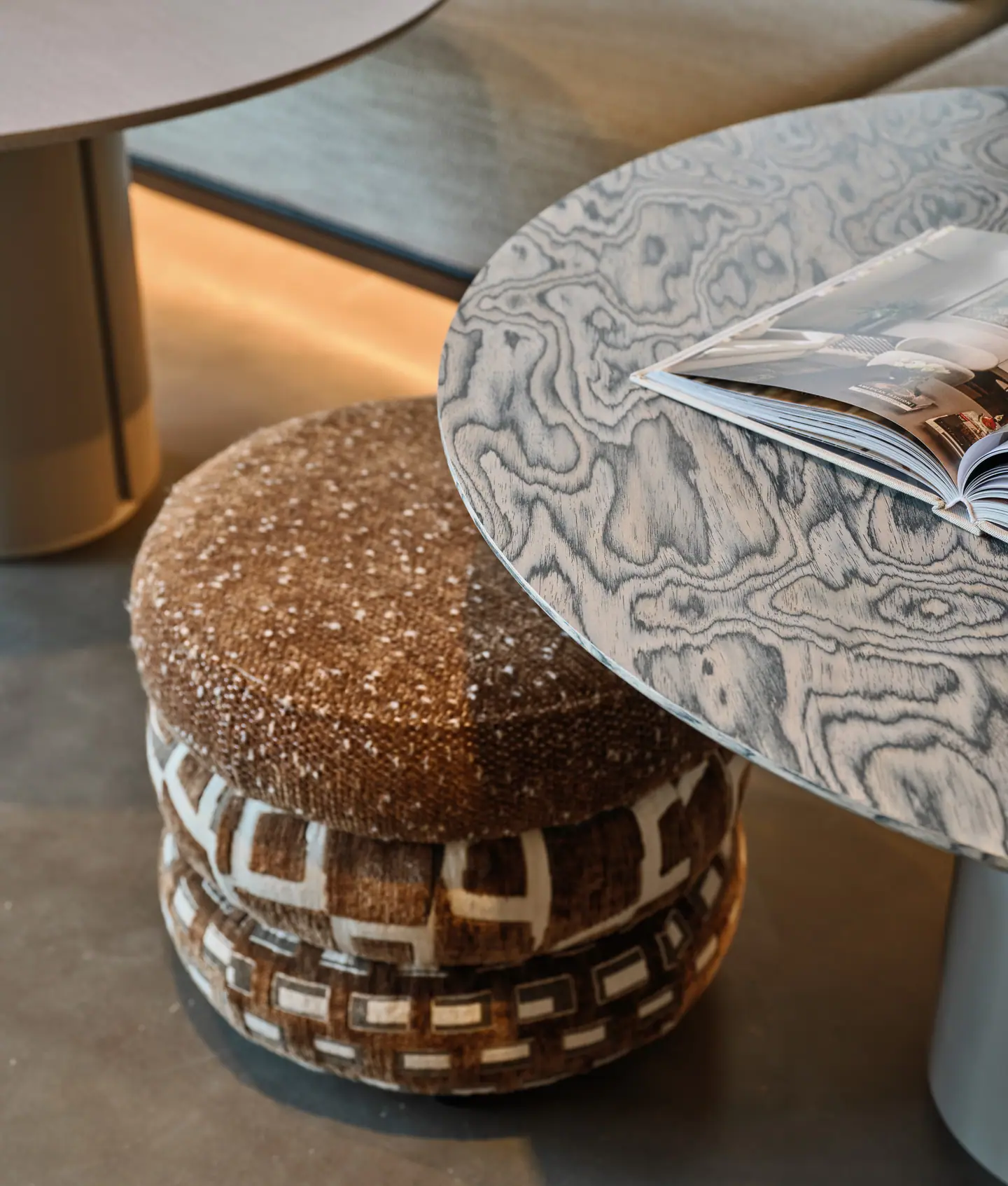 A boucle pouf beside a figured-wood side table in the Beykoz showroom
